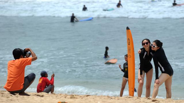 TURIS domestik mengikuti kelas surfing di Pantai Kuta.