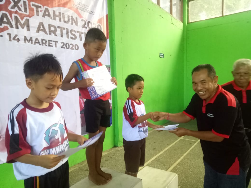 KETUA Umum Persani Kota Denpasar, Made Dana Tenaya, menyerahkan hadiah kepada peraih juara senam artistik antarklub Walikota Cup XI/2020 pada Sabtu (14/3/2020). Foto: putra sasmitha
