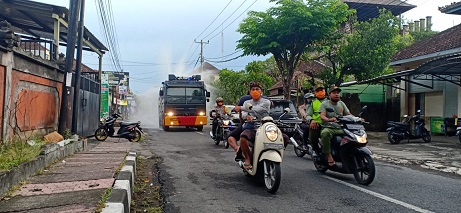 PENYEMPROTAN disinfektan oleh Satgas Gotong Royong Covid-19 Desa Adat Yangbatu bersama Polresta Denpasar dan Polda Bali di jalanan yang melintasi Desa Adat Yangbatu, Minggu (5/4). Foto: ist