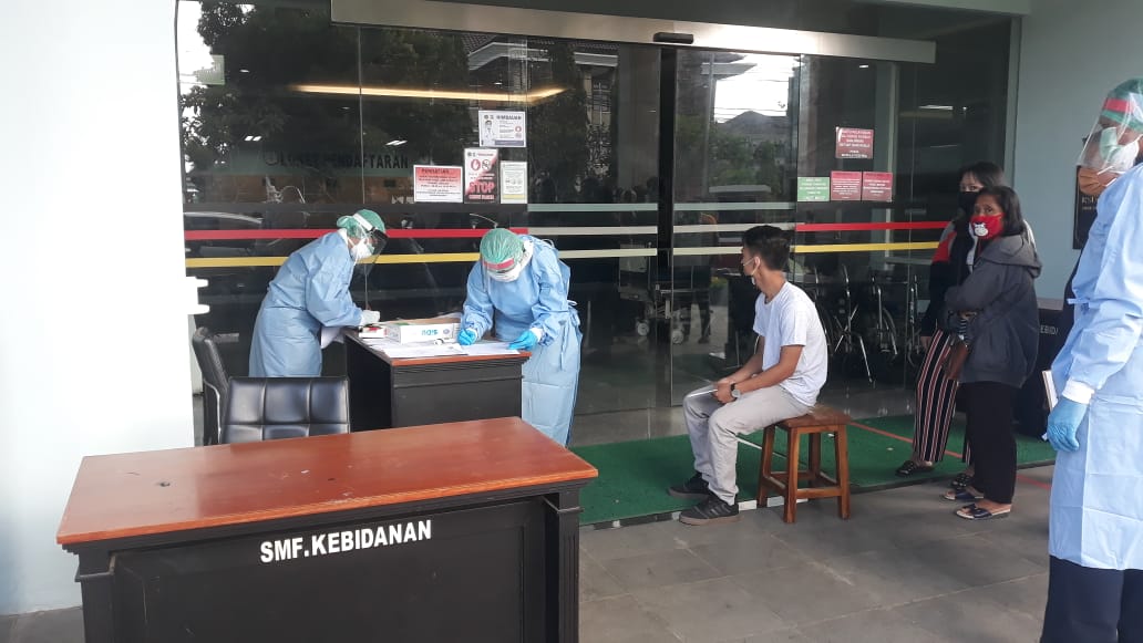 PETUGAS memakai APD lengkap melakukan screening test setiap pengunjung maupun petugas yang hendak memasuki area RSUD Sanjiwani Gianyar. Foto: adi
