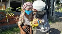 polwan sosialisasi Corona POLWAN Polda Bali memasangkan masker kepada seorang nenek dalam sosialisasi pencegahan penularan Covid-19, Sabtu (11/4/2020). Foto: Ist
