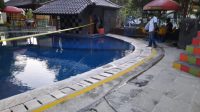 JAJARAN Polsek Seririt memasang garis polisi disekitar kolam lokasi tenggelamnya seorang bocah berusia 11 tahun. Foto: rik JAJARAN Polsek Seririt memasang garis polisi disekitar kolam lokasi tenggelamnya seorang bocah berusia 11 tahun. Foto: rik