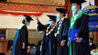 REKTOR Universitas Udayana, Prof. Dr. dr. A.A Raka Sudewi, Sp.S(K), memindahkan tali toga kepada salah seorang wisudawan saat gelaran Wisuda Unud Ke-138, Sabtu (24/10/2020) yang berlangsung secara daring. Foto: ist REKTOR Universitas Udayana, Prof. Dr. dr. A.A Raka Sudewi, Sp.S(K), memindahkan tali toga kepada salah seorang wisudawan saat gelaran Wisuda Unud Ke-138, Sabtu (24/10/2020) yang berlangsung secara daring. Foto: ist