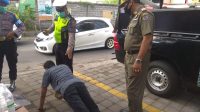 SALAH seorang pelanggar dihukum push up oleh tim yustisi saat pelaksanaan sidak masker di wilayah Desa Peguyangan Kangin, Kecamatan Denpasar Utara, Selasa (17/11/2020). Foto: ist SALAH seorang pelanggar dihukum push up oleh tim yustisi saat pelaksanaan sidak masker di wilayah Desa Peguyangan Kangin, Kecamatan Denpasar Utara, Selasa (17/11/2020). Foto: ist