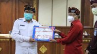 DIPA Bawaslu Bali KETUT Rudia (kiri) menerima penyerahan DIPA tahun 2021 dari Gubernur Wayan Koster di Wiswa Sabha kantor Gubernur Bali, Kamis (26/11/2020). Foto: Ist