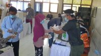 KPPS TPS 9 di Kelurahan Serangan memasangkan sarung tangan plastik kepada pemilih sebelum mendapat surat suara, dalam simulasi Pilkada Denpasar 2020, Sabtu (21/11/2020). KPU Bali mencatat sejumlah hal yang perlu perbaikan dari simulasi untuk diperbaiki saat 9 Desember nanti. Foto: hen KPPS TPS 9 di Kelurahan Serangan memasangkan sarung tangan plastik kepada pemilih sebelum mendapat surat suara, dalam simulasi Pilkada Denpasar 2020, Sabtu (21/11/2020). KPU Bali mencatat sejumlah hal yang perlu perbaikan dari simulasi untuk diperbaiki saat 9 Desember nanti. Foto: hen