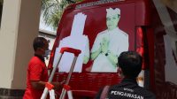 penutupan branding di Badung BAWASLU Badung bersama pegawai Pemkab Badung menutup foto paslon petahana yang dipasang di mobil operasional Pemkab Badung. Foto: Ist