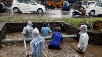 PETUGAS PUPR Kota Denpasar berjibaku menaikkan sampah yang menyumbat saluran drainase, Senin (14/12/2020). Foto: ist PETUGAS PUPR Kota Denpasar berjibaku menaikkan sampah yang menyumbat saluran drainase, Senin (14/12/2020). Foto: ist