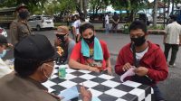 PROKES KLUNGKUNG PETUGAS Satpol PP Klungkung memberi sanksi denda kepada warga yang melanggar prokes di Jalan Raya Goa Lawah, Kecamatan Dawan, Rabu (2/12/2020). Foto: ist
