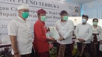 Plh Ketua KPUD Bangli, I Gede Roy S., menyerahkan hasil keputusan pleno penetapan Bupati dan Wakil Bupati Bangli terpilih Sang Nyoman Sedana Arta-Wayan Diar. Foto: gia Plh Ketua KPUD Bangli, I Gede Roy S., menyerahkan hasil keputusan pleno penetapan Bupati dan Wakil Bupati Bangli terpilih Sang Nyoman Sedana Arta-Wayan Diar. Foto: gia