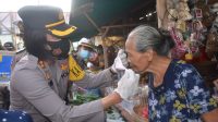 KAPOLRES Karangasem, AKBP Ni Nyoman Suartini, sedang memasangkan masker pada salah seorang pedagang di Pasar Desa Adat Ulakan, Kecamatan Manggis. Foto: ist KAPOLRES Karangasem, AKBP Ni Nyoman Suartini, sedang memasangkan masker pada salah seorang pedagang di Pasar Desa Adat Ulakan, Kecamatan Manggis. Foto: ist