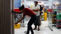PEKERJA toko modern di Kecamatan Dawan menutup pintu toko setelah Tim Satgas Covid-19 melihat toko tersebut masih melayani pembeli di atas pukul 21.00, Selasa (12/1/2021). Foto: ist PEKERJA toko modern di Kecamatan Dawan menutup pintu toko setelah Tim Satgas Covid-19 melihat toko tersebut masih melayani pembeli di atas pukul 21.00, Selasa (12/1/2021). Foto: ist