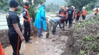PETUGAS BPBD Buleleng dibantu warga Desa Sepang Kelod saat membersihkan sisa material longsor yang menutup jalan. Foto: rik PETUGAS BPBD Buleleng dibantu warga Desa Sepang Kelod saat membersihkan sisa material longsor yang menutup jalan. Foto: rik
