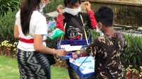 PEMUDA KNPI di Klungkung membagikan masker kepada anak penjual tisu di Monumen Puputan Klungkung. Foto: ist PEMUDA KNPI di Klungkung membagikan masker kepada anak penjual tisu di Monumen Puputan Klungkung. Foto: ist