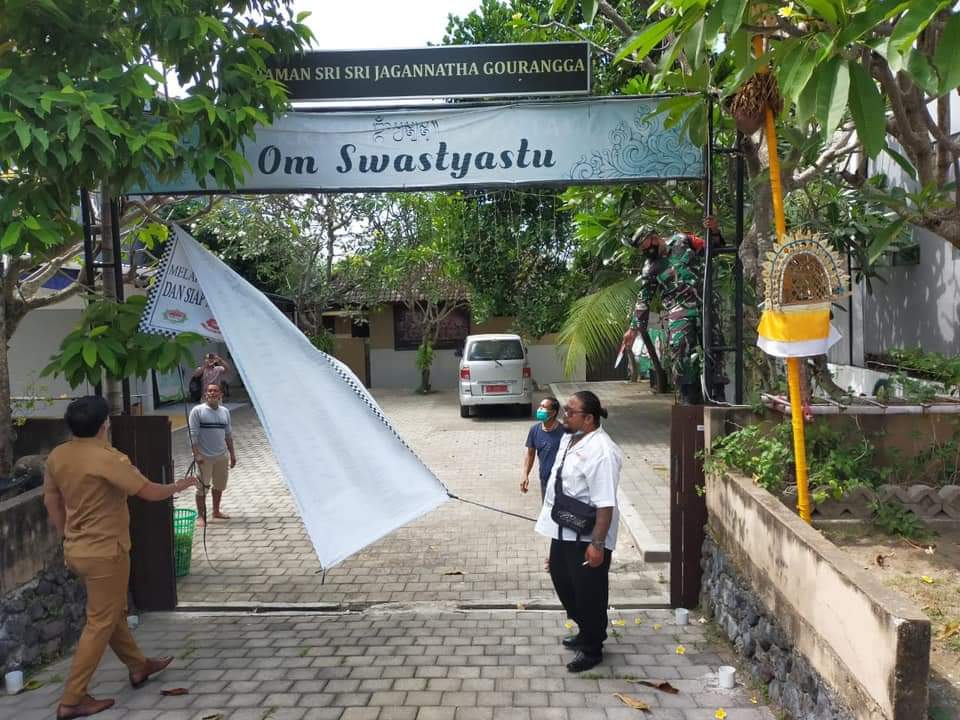 SPANDUK penutupan ashram di Jalan Tukad Balian, Desa Sidakarya, Kota Denpasar, diturunkan oleh aparat desa setempat, Senin (17/5/2021). Sebelumnya spanduk tersebut dipasang oleh massa dari sejumlah ormas. Foto: ist