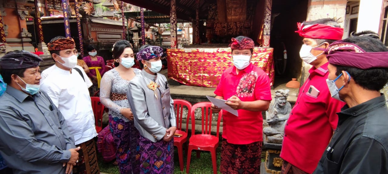 BUPATI Bangli, Sang Nyoman Sedana Arta, menyerahkan akta pernikahan, KTP dan KK atas nama I Wayan Suwendra dengan Ni Wayan Sintia di Br. Tiga, Desa Tiga, Susut, Sabtu (5/6/2021). Foto: ist
