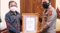 Gubernur Koster saat menerima penghargaan Kapolri yang diserahkan Kapolda Bali.
