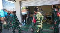 ANGGOTA Kodim 1609 Buleleng dibantu jajaran Koramil Banjar, memperbaiki salah satu rooling door warung
