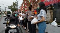 BULAN Sutena mendampingi Kapolsek Ubud membagikan sembako gratis. Foto: adi BULAN Sutena mendampingi Kapolsek Ubud membagikan sembako gratis. Foto: adi