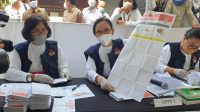 KOMISIONER Luh Putu Widyastini yang berperan sebagai KPPS membuka lembar surat suara sebelum memulai proses pemungutan suara saat simulasi di TPS 01, Kamis (2/12/2021). Foto: hen KOMISIONER Luh Putu Widyastini yang berperan sebagai KPPS membuka lembar surat suara sebelum memulai proses pemungutan suara saat simulasi di TPS 01, Kamis (2/12/2021). Foto: hen
