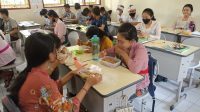 SISWA salah satu sekolah di Denpasar, makan dan minum di kelas saat jam istirahat karena kantin belum boleh beroperasi. Foto: tra SISWA salah satu sekolah di Denpasar, makan dan minum di kelas saat jam istirahat karena kantin belum boleh beroperasi. Foto: tra