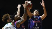 Yonatan (kiri) berebut bola dengan dua pebasket Rans