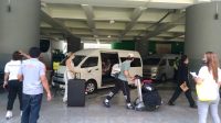 Penumpang Singapore Airlines yang diarahkan menuju bus yang disediakan setelah melewati serangkaian proses usai landing di Bandara Ngurah Rai