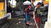 Beberapa orang gepeng melakukan aksi bersih-bersih di areal Padmasana kantor Dinsos