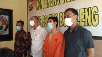 TERSANGKA Komang Arik (pakai baju tahanan) yang terjerat kasus UU ITE saat dihadirkan di Mapolres Buleleng