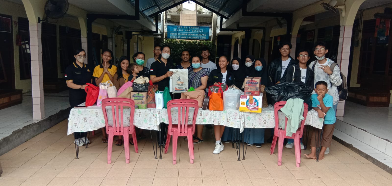 WAKASEK Humas SMK TI Bali Global Badung, Ida Ayu Made Ari Widyawati, S.Pd.H., saat mendampingi siswa membagikan bingkisan saat rahina Tumpek Krulut, Sabtu (18/2/2023) di panti asuhan. Foto: ist