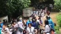 TANGKAPAN layar video yang beredar di media sosial, terlihat beberapa siswa SMPN 3 Amlapura bergotong royong menyeberangkan sepeda motor agar bisa lewat jalan yang “diputus” air sungai lumayan deras. Foto: ist TANGKAPAN layar video yang beredar di media sosial, terlihat beberapa siswa SMPN 3 Amlapura bergotong royong menyeberangkan sepeda motor agar bisa lewat jalan yang “diputus” air sungai lumayan deras. Foto: ist