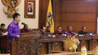 NYOMAN Budiutama saat membacakan laporan akhir Dewan yang menyetujui pengesahan Ranperda tentang Penyelenggaraan Ketertiban Umum, Ketenteraman Masyarakat dan Pelindungan Masyarakat menjadi Perda dalam rapat paripurna, Senin (10/4/2023). Foto: ist NYOMAN Budiutama saat membacakan laporan akhir Dewan yang menyetujui pengesahan Ranperda tentang Penyelenggaraan Ketertiban Umum, Ketenteraman Masyarakat dan Pelindungan Masyarakat menjadi Perda dalam rapat paripurna, Senin (10/4/2023). Foto: ist