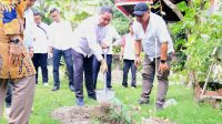 BAWASLU BALI HERWYN JH. Malonda (pegang sekop) saat menguruk tanah di pohon manggis yang ditanam di halaman kantor Bawaslu Bali, Rabu (31/7/2024). Foto: ist