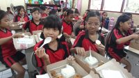 SISWA di SDN 17 Dangin Puri, Denpasar Utara, saat menikmati makan bergizi gratis dari Disdikpora Kota Denpasar pada Sabtu (21/12/2024). Foto: tra SISWA di SDN 17 Dangin Puri, Denpasar Utara, saat menikmati makan bergizi gratis dari Disdikpora Kota Denpasar pada Sabtu (21/12/2024). Foto: tra