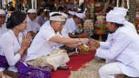BUPATI Satria menyerahkan punia kepada panitia upacara karya di Pura Tuluk Biyu, Kintamani, Kabupaten Bangli, Kamis (9/10/2025). Foto: ist